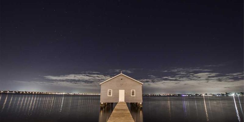 一锅炖煮着红烧肉的锅，锅身上布满了岁月的痕迹，旁边是忙碌着的家庭主妇，背景是温馨的厨房，营造出一种家的温馨氛围